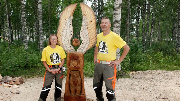 Elli ja Kari Viinikangas poseeraavat kunniamaininnan saaneen työnsä vieressä Ilomantsin Karhufestivaaleilla 2020