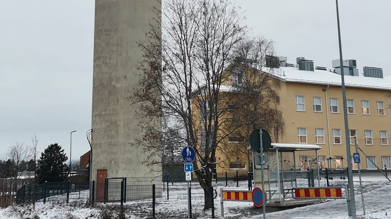 Vesitorni matalan asuinrakennuksen vieressä.