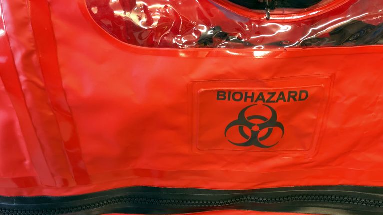 Biohazard-varoitus potilaan eristyskapselin kyljessä.