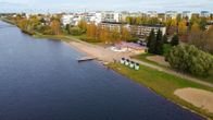 Uimaranta, laituri ja keltainen rakennus sekä taustalla kerrostaloja.
