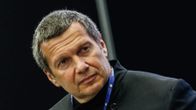 TV-juontaja Vladimir Solovjov lähikuvassa, katsoo yläviistoon.