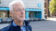 Arne Wessberg står i närbild framför Yles ingång.  