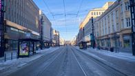 Tampereen keskustan Hämeenkatu lähes autiona bussilakon aamuna. Taivas on sininen ja aamuaurinko osuu rakennusten kattoihin.