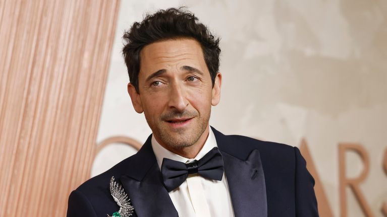 Adrien Brody mustassa smokissa, jonka rintapielessä hopea siipikoriste.