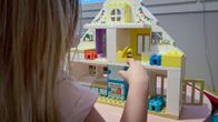 Lapsi leikkii legotalolla.