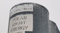 A dark grey cylindrical structure that looks like a grain silo with the words "Polar Night Energy" seen on the side.