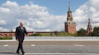 Vladimir Putin går på ett stenlagt torg framför Kremls murar och torn i Moskva. Ingen synlig text i bilden.