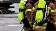 Pelastuslaitoksen työntekijät seisovat sateisessa Turun satamassa.