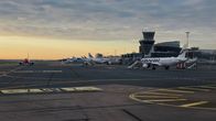 Helsinki-Vantaan lentoasema asematasolta kuvattua. Kuvassa Finnairin ja Norwegianin koneita ja taustalla terminaalirakennus.