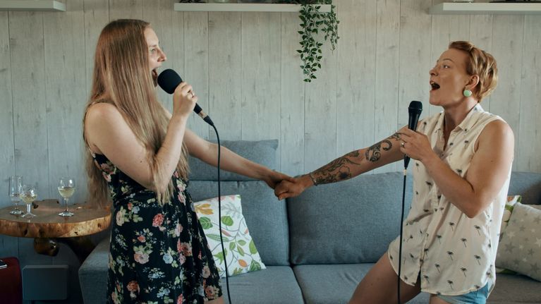 Laura som sjunger karaoke med sin kompis i dokumentären Karaokeparatiisi.
