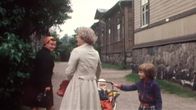 Kaksi naista, lastenvaunut ja lapsia Ruoholahden villojen edustalla.