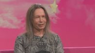 Stratovarius-yhtyeen keulahahmo Timo Kotipelto Puoli seitsemän -ohjelman studiossa istumassa pinkillä sohvalla. 