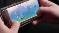 Mobilspel: två händer håller en mobil på tvären och spelar ett av Nitro Games spel.