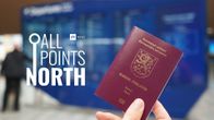 Photo shows a person's hand holding a Finnish passport with the All Points North logo on the side.