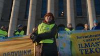 En kvinna med gul väst i en demonstration.