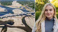 Ilmakuva joesta ja sillasta, jossa vedenpinta on matalalla, sekä henkilö seisomassa ulkona vehreässä ympäristössä.