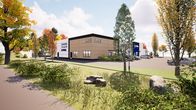 Ett nybyggt hus med skyltarna "Antell", "Caverion" och "Etra" omges av parkeringsplatser och grönska.