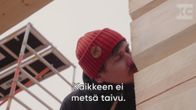 Toimittaja Tuukka Pasanen haistaa rakennettavan puutalon seinää.