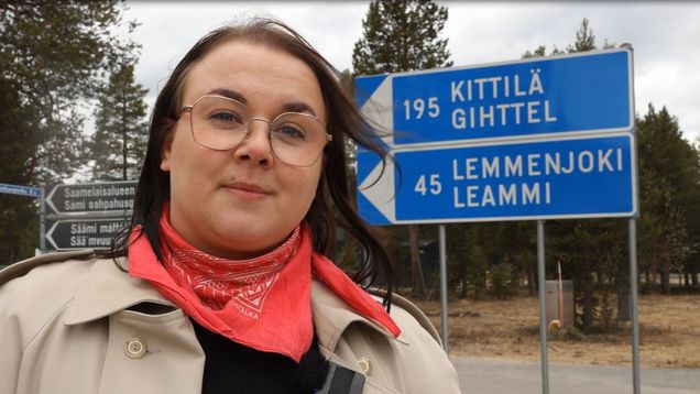 Nainen seisoo tienviittojen edessä. Toimittaja Sara Kelemeny. 