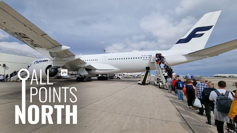 Photo shows a queue of people waiting to board a Finnair aircraft at Las Palmas airport.