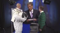 Presidentti Niinistö katsoo astronauttipukuista miestä.