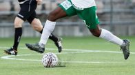 Fotbollsspelare och boll på konstgräs.