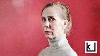 Kati Outinen eläytyy Helene Schjerfbeckin omakuvaan. Vakava nainen kuvattuna vahvan punaista taustaa vastaan. 