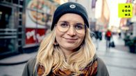 Silva Belghiti seisoo kadulla, katsoo hymyillen kameraan.