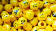 Lego-hahmojen päitä, joissa erilaisia ilmeitä.