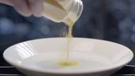 Soleiini-proteiinijauhetta ravistellaan purkista lautaselle.