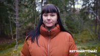 Puolikuva Annasta, joka katsoo kameraan. Annalla on oranssi toppatakki ja mustat pitkät hiukset.
