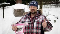 Mies pitää pinkkiä dronea kädessä