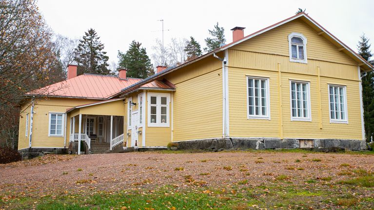 Keltainen asumiskäyttöön remontoitu koulurakennus.