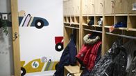 Lastenvaatteita roukkuu päiväkodin naulakossa.