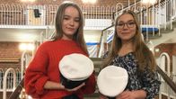 Ada Rantala (vas) ja Emilia Tammilehto valkolakit kädessä Lyseonpuiston lukion juhlasalissa.