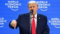 Donald Trump puhuu mikrofoniin puhujankorokkeella ja osoittaa sormellaan alaspäin.