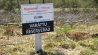 En vit skylt där det står att tomten är till salu. 