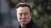 Elon Musk ulkona musta takki päällään.