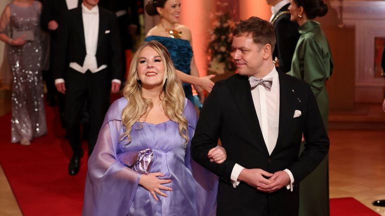 Alviina Alametsä ja jaakko Mustakallio kävelevät punaisella matolla. Alametsällä laventelin värinen iltapuvu. Hän pitää kättä vatsallaan.