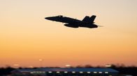 Hornet-hävittäjä lentää yöllistä taivasta vasten.