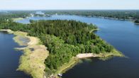 Aerial photo of a forested peninsula on a body of water.