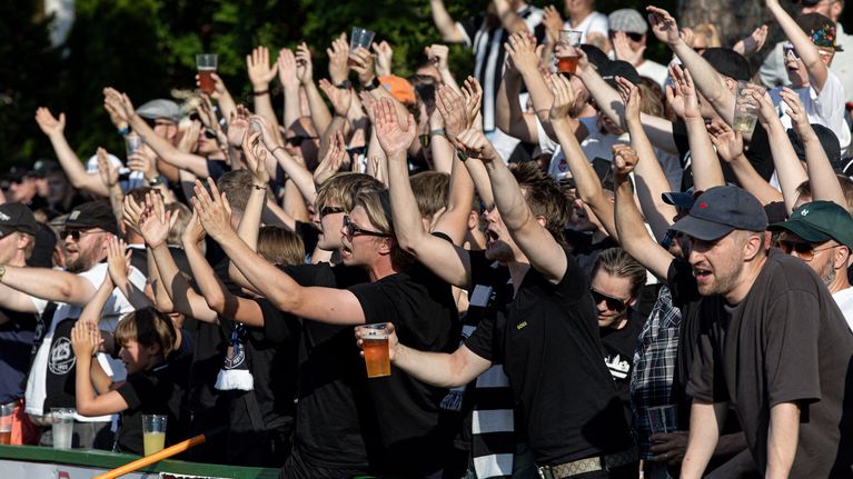 Många TPS-anhängare höjer armarna mot himlen.