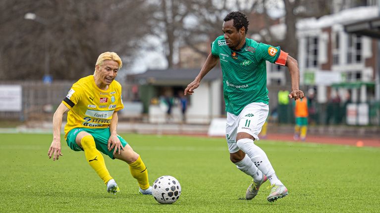 En spelare med grön tröja fintar en spelare med gul tröja.