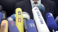 Eri mediatalojen mikrofoneja kohti haastateltavaa.