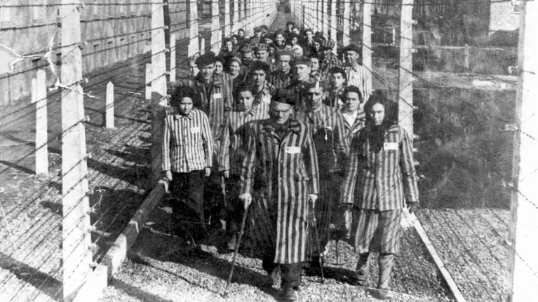 Auschwitzin keskitysleiriltä hengissä selvinneet kävelevät ulos leiristä.