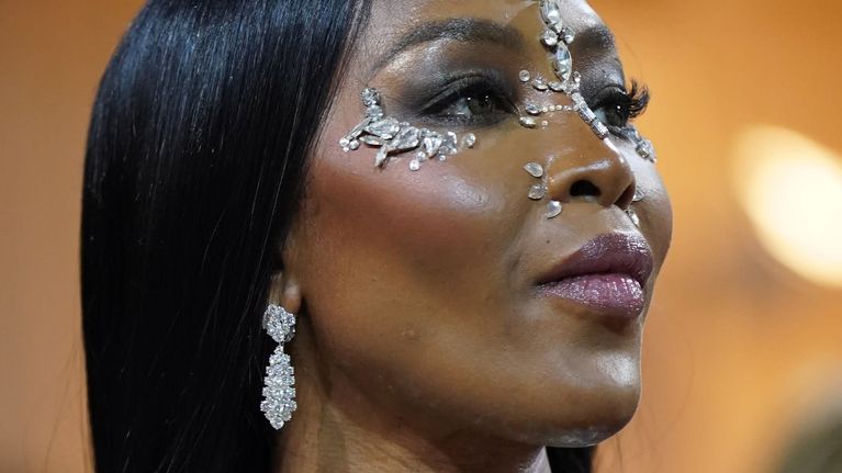 Naomi Campbell  Burberryn asyssa ja kasvoillaan jalokiviornamentteja.