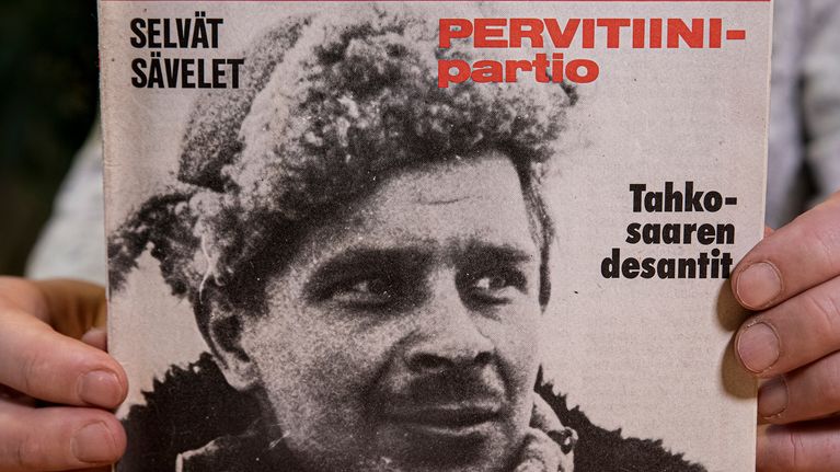 Mika Koivunen pitelee sormissaan Kansa taisteli -lehteä vuodelta 1978, jonka kannessa on hänen isänsä Aimo Koivusen kuva.