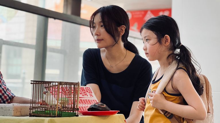 Taiwanilainen äiti tyttärensä kanssa pöydän ääressä.