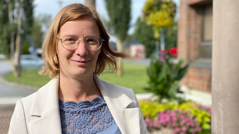 Kvinna med glasögon, neutralt leende. 