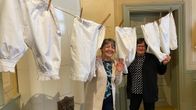 Naisten vanhoja alushousuja narulla. Välistä kurkistelevat museolta Carola Sundqvist ja Ann-Marie Knif-Sandelin